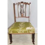 A fine Regency style chair with intricately carved and inlaid lyre back, ceramic castors, upholstery