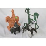 Four assorted classical/naive horse and rider figurines: three metal, one clay