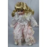 Doll on stand in pink and white dress