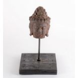 A Chinese bronze head of Buddha  mounted to a wooden display stand, the head with floral