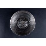A white metal Islamic bowl of ribbed, circular form, the central well with embossed goat and foliate