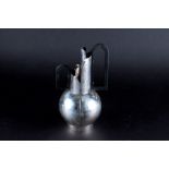 A graduated pair of Continental silver modernist jugs with ebonised loop handles and hammered
