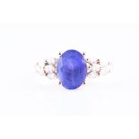A diamond and tanzanite ring set with a mixed oval-cut tanzanite, measuring approximately 10 x 8 mm,