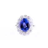 An impressive platinum, diamond, and tanzanite cluster ring centred with a mixed oval-cut tanzanite,