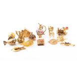 Fourteen yellow metal (all test gold) charms, mostly mid 20th century including an articulated steam