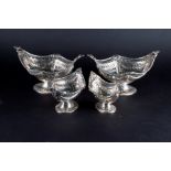 Two matched pairs of silver pierced pedestal dishes of shaped oval form, various dates and makers,