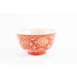 A Chinese Qing dynasty coral red reverse decorated bowl with foliate scrolled decoration and