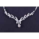 An 18ct white gold and diamond necklace suspended with a round brilliant-cut diamond of