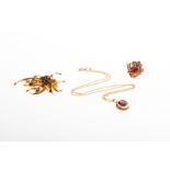 A 9ct yellow gold and garnet floral brooch centred with a floral cluster of five round-cut garnets