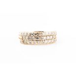 A yellow metal and diamond band ring set with three rows of small round-cut diamonds, the shank