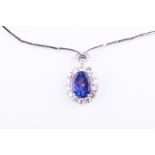 An 18ct white gold, diamond, and tanzanite drop pendant necklace the oval cluster pendant centred