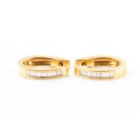 A pair of yellow metal and diamond hoop earrings the mounts inset with calibre-set baguette-cut