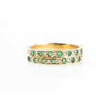 A yellow metal, diamond, and emerald ring the band inset with two rows of alternating round-cut