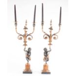 A pair of 19th century Continental carved wood candelabra modelled as putti standing on fluted