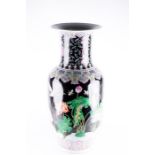 A large 20th century famille noire porcelain baluster vase decorated with applied polychrome enamels