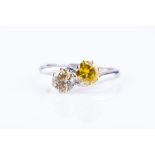 A platinum and yellow diamond crossover ring set with a pale yellow round brilliant-cut diamond