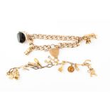 A 9 carat gold charm bracelet suspended with three charms including a weighing scale, together