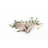 A mid 20th century diamond and emerald spray brooch set in unmarked white metal (tests as gold), the