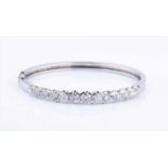 An 18ct white gold and diamond hinged bangleset with thirteen round brilliant-cut graduated diamonds