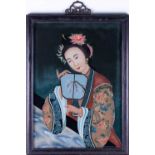A Chinese reverse painting on glass of a young woman holding a small screen in her hand against a