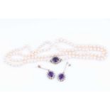 An opera length pearl necklaceof cream-coloured cultured pearls, with a 9ct yellow gold, amethyst,