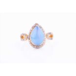 A silver gilt opal and diamond ringset with a pear-shaped cabochon opal within a border and