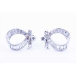 A pair of ribbon-twist diamond earringsthe mounts set with tapered baguette-cut diamonds and