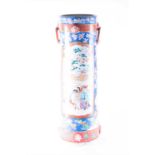 An early 20th century Japanese ceramic stick stand decorated in polychrome enamels, with reserves of