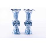 A near pair of Chinese Qing dynasty blue and white porcelain clobbered gu-shape vasespossibly Kangxi