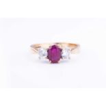 A 9 carat gold ruby and diamond ringcentred mixed oval-cut ruby, flanked with two round brilliant-
