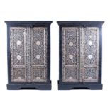 A pair of late 20th century ebonised and mother-of-pearl inlaid cabinets with twin cupboard doors,