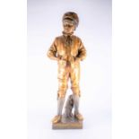 A large Goldscheider bronzed earthenware figure of a finely dressed boy his hands in his pockets