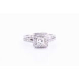 A diamond cluster ringcentered with a princess-cut diamond of approximately 0.30 carats, within a