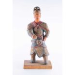 A 20th century Chinese carved and painted wooden warrior mounted to a wooden rectangular base.57