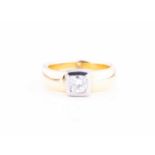A diamond solitaire ring in yellow and white metalset with a brilliant-cut diamond of