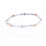 A yellow and white metal diamond braceletthe pinched bone-links interspersed with yellow metal and