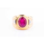 A yellow metal, synthetic ruby, and diamond ringthe wide band inset with a mixed-cut ruby, the