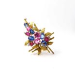 A yellow metal and sapphire brooch, in the abstract taste, the mount with foliate design, set with