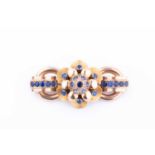 A 9 carat yellow gold and sapphire brooch, the elongated bar brooch centred with a floral design,