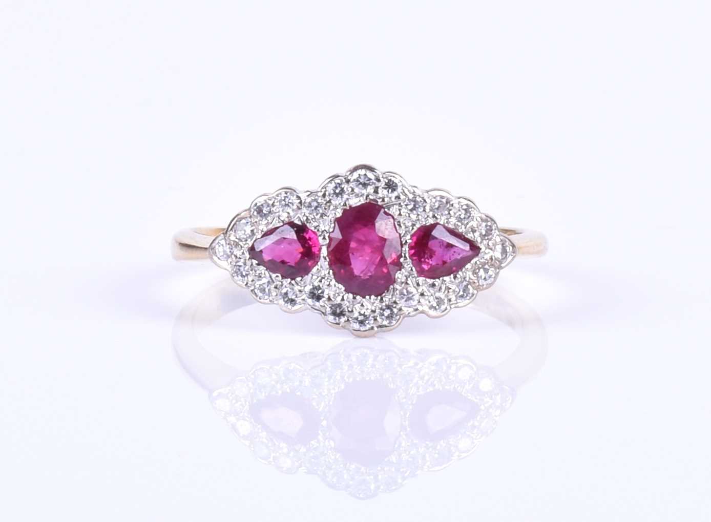 An 18ct yellow gold, diamond and ruby ring, centred with a mixed oval-cut ruby flanked with two - Image 2 of 4