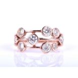 An 18ct rose gold and diamond ring, in the Boodles style, the three bands scatter-set with round