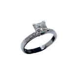 An 18ct white gold and diamond ring, the central princess cut diamond in a 4 claw setting of I