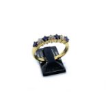 An 18 carat yellow gold, sapphire and diamond ring, set with three brilliant cut diamonds of J