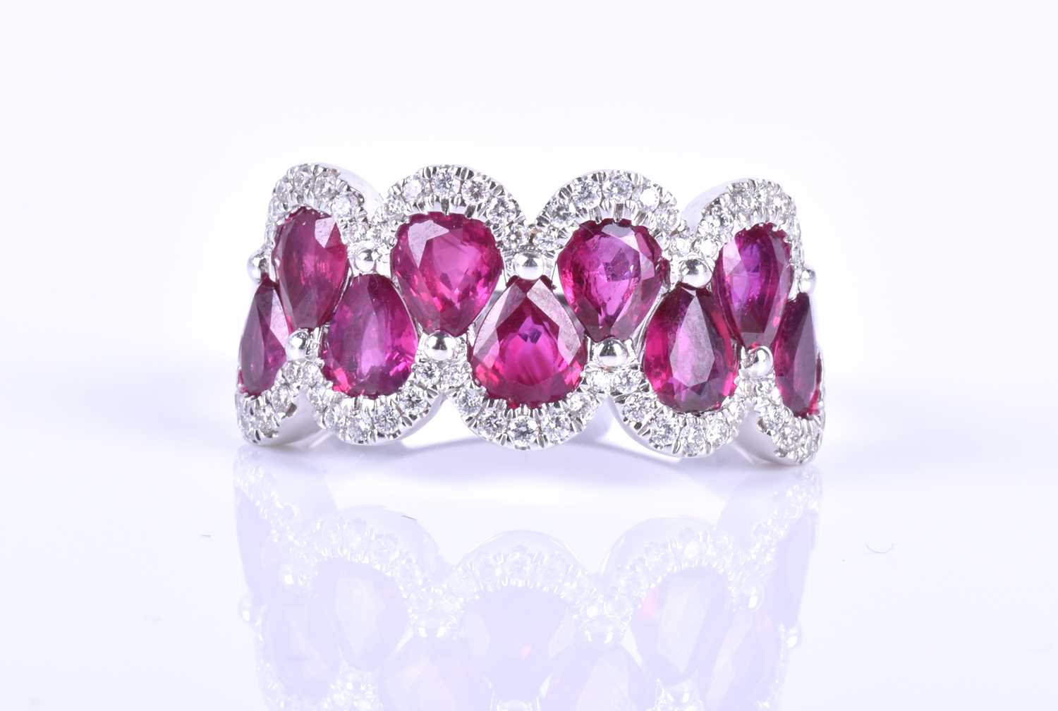 An 18ct white gold, diamond and ruby ring, the rounded mount set with a row of mixed pear-cut rubies - Image 6 of 6