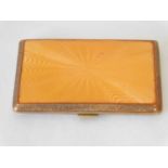 A Geo V ladies cigarette case, with orange coloured guilloche enamel style lid with cast foliate