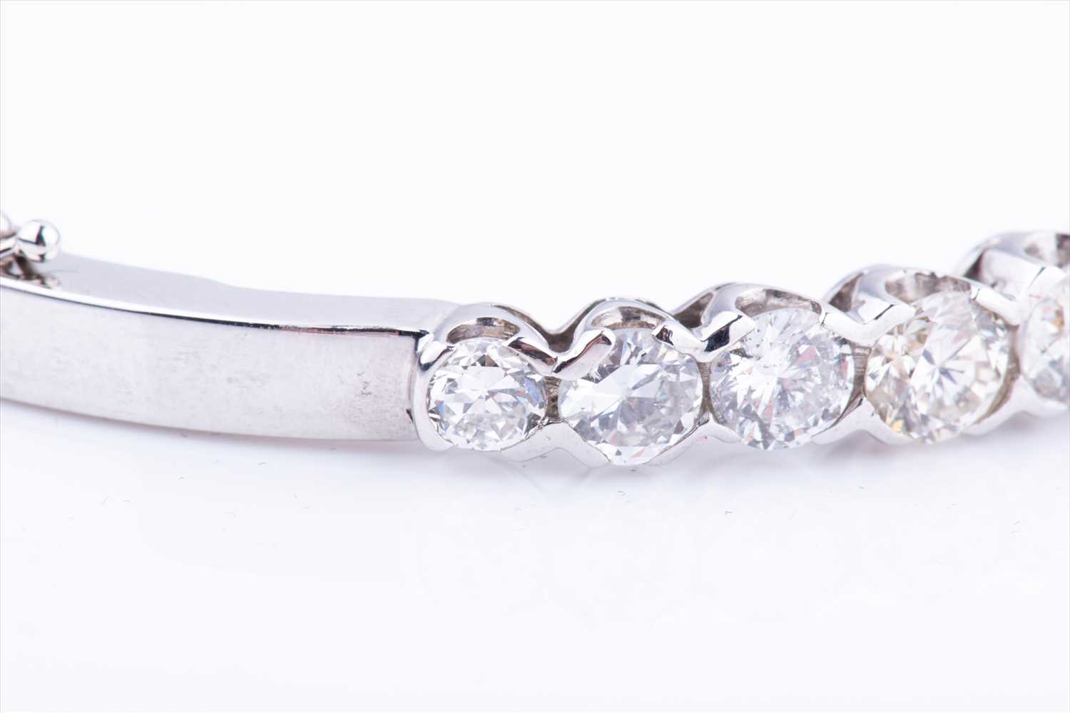 An 18ct white gold and diamond hinged bangle, set with thirteen round brilliant-cut graduated - Image 2 of 6