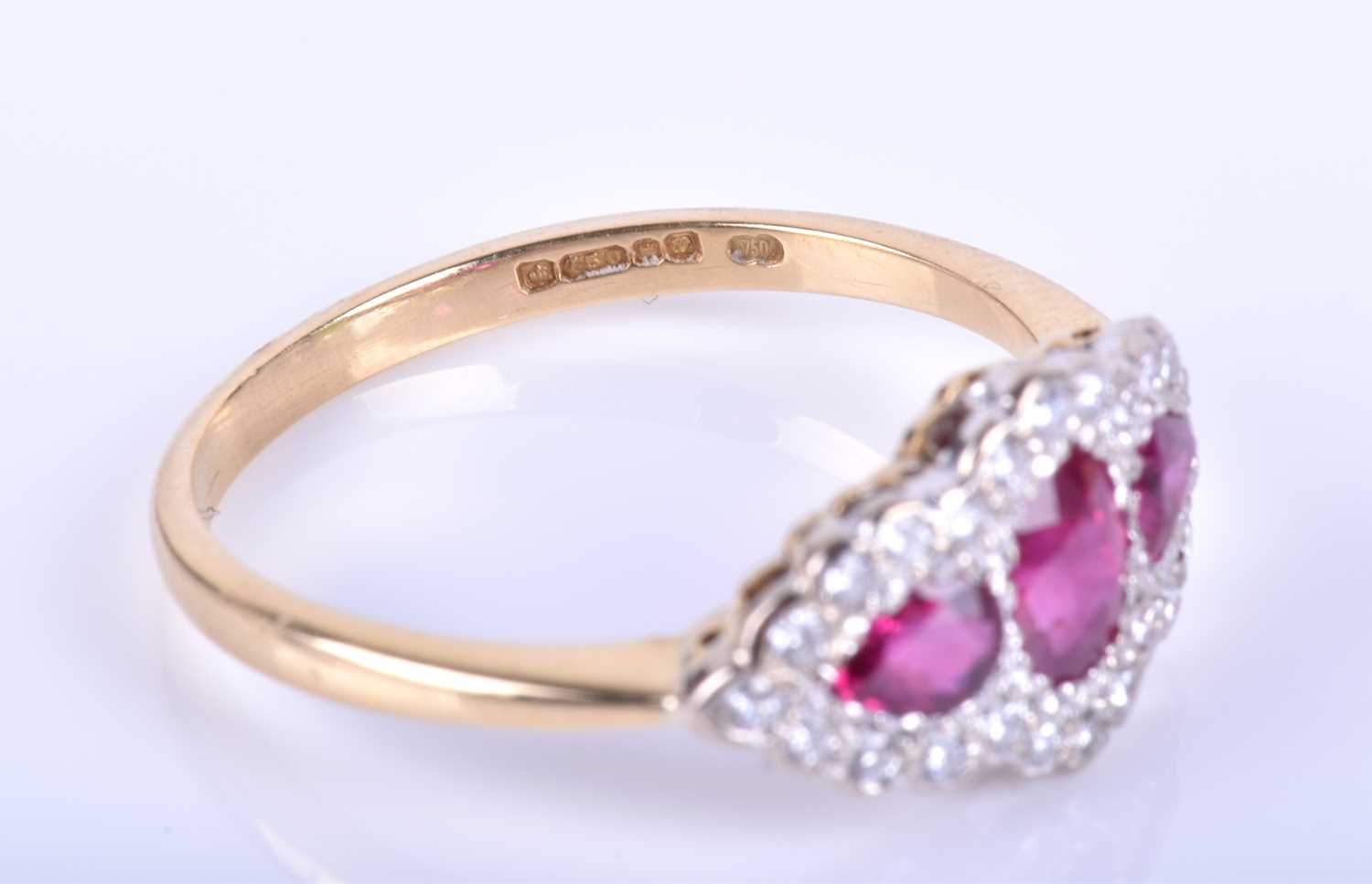 An 18ct yellow gold, diamond and ruby ring, centred with a mixed oval-cut ruby flanked with two - Image 4 of 4