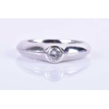 A platinum and solitaire diamond ring, of unusual design, the round brilliant-cut diamond rubover