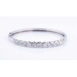 An 18ct white gold and diamond hinged bangle, set with thirteen round brilliant-cut graduated