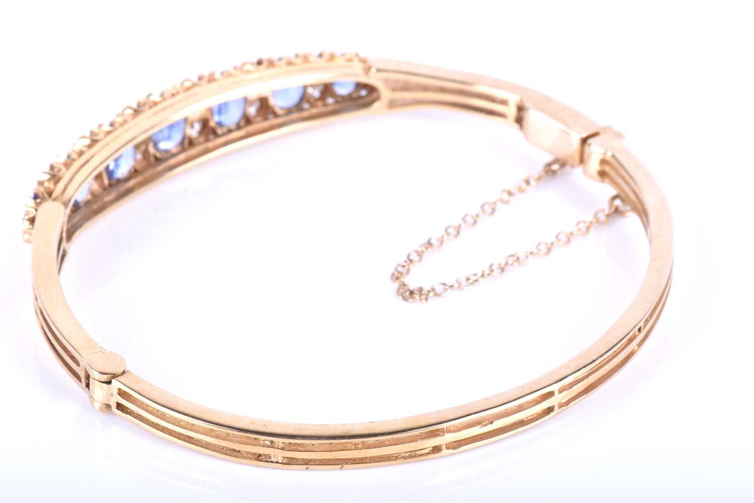 A 9ct yellow gold, diamond and sapphire bangle, set with seven graduated mixed oval cut blue - Image 4 of 6